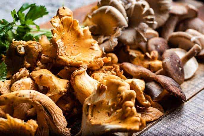 A variety of mushrooms on a wooden board from Gourmet Done Skinny