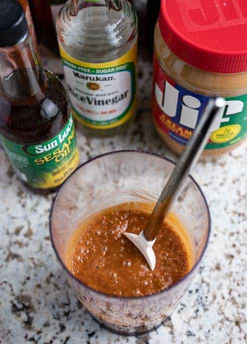 stir fry sauce with spatula, soy sauce, rice vinegar and peanut butter in background
