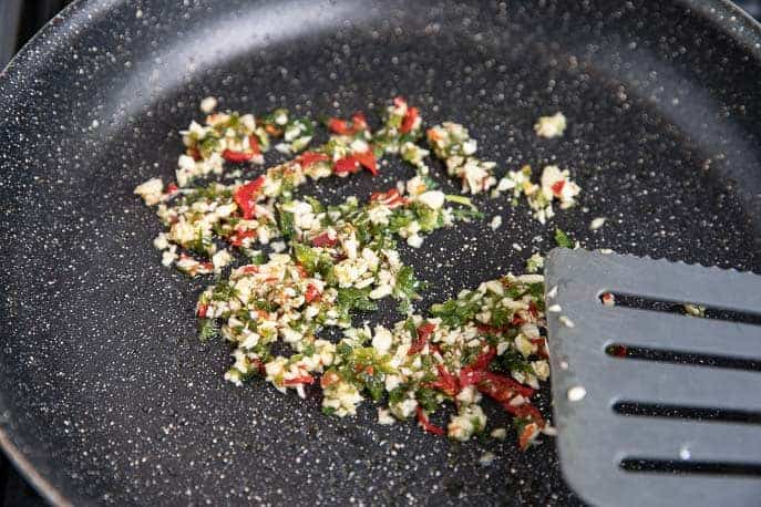 garlic, jalapeno peppers and peppers in a non stick skillet with a plastic spatula
