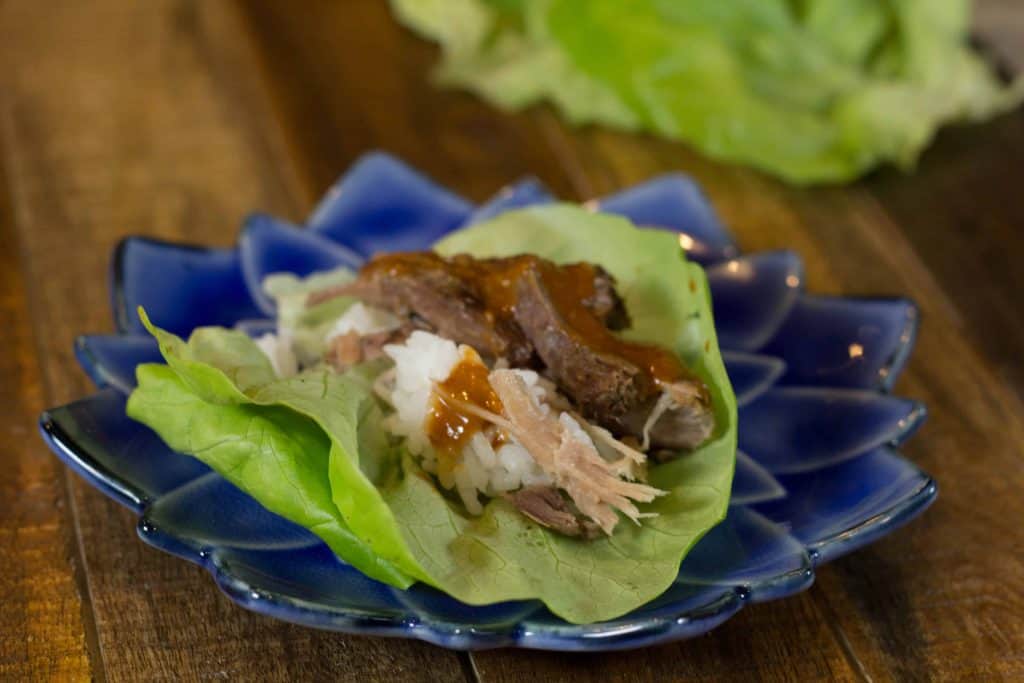 Lettuce wraps with Kalua Pork on a blue lotus plate