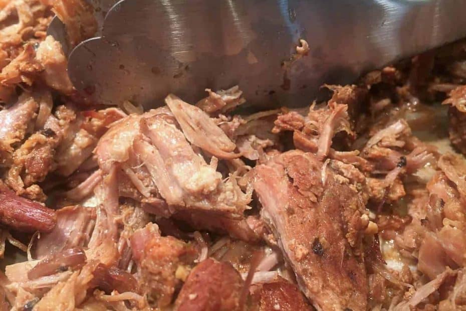 pork carnitas with stainless steel tongs
