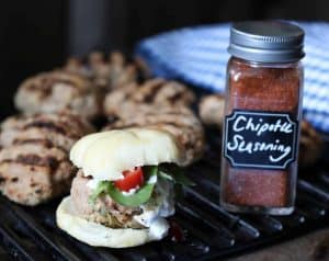 Spicy Jalapeño Adobo Turkey Slider on a grill with Chipotle Seasoning in a glass jar