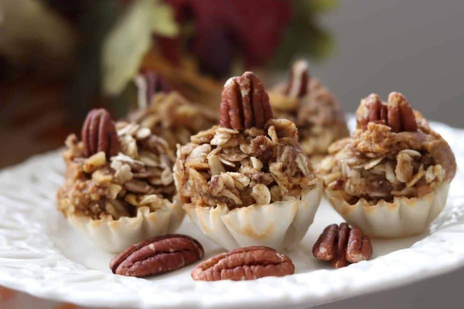 Easy Healthy Mini Pumpkin Pies with Cinnamon Cardamom Streusel on a cream plate with pecans.