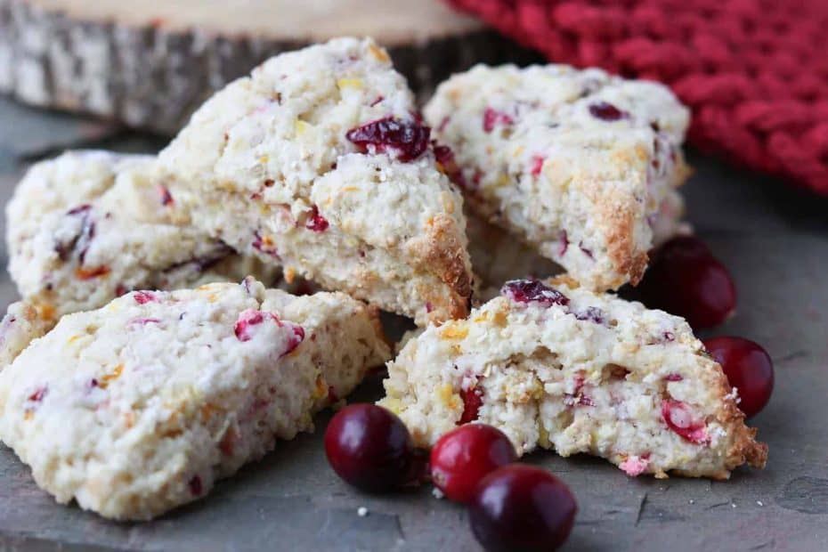 Delicious moist healthy homemade cranberry orange scones on a grey slate with fresh cranberries