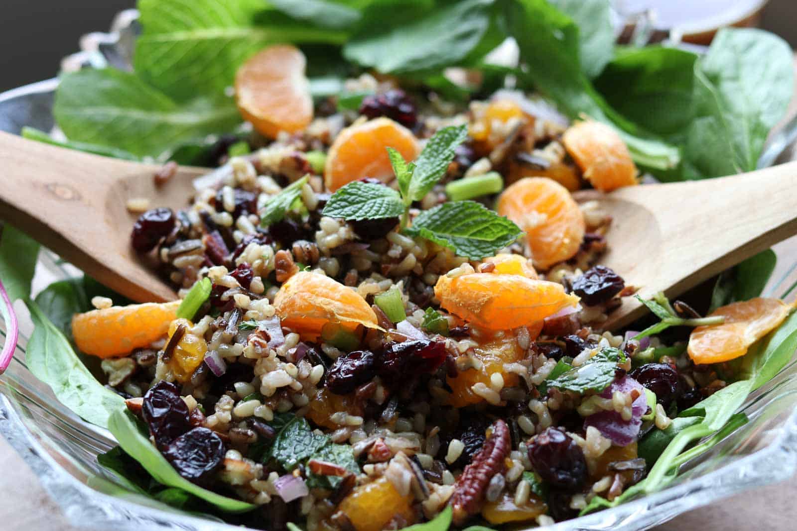 Mandarin Wild Rice Salad is a hearty autumn salad with cranberries, pecans, green onions, chopped mint and mandarins with a delightful orange vinaigrette in a glass bowl from Gourmet Done Skinny