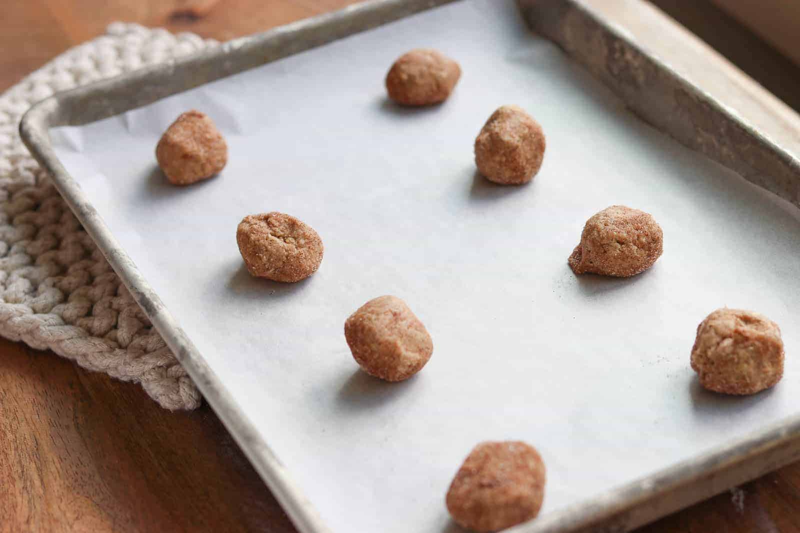 Cinnamon Oodle cookie dough balls on a baking sheet lined with parchment paper from Gourmet Done Skinny