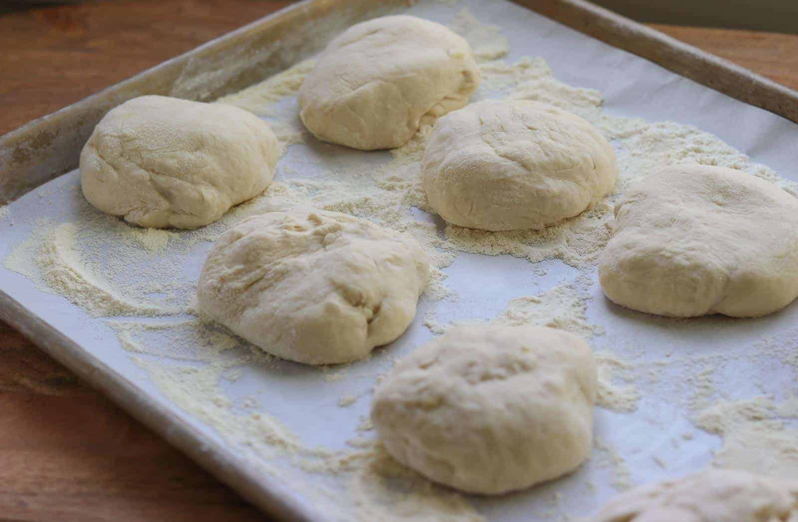 Pizza dough on a baking sheet lined with parchment from Gourmet Done Skinny