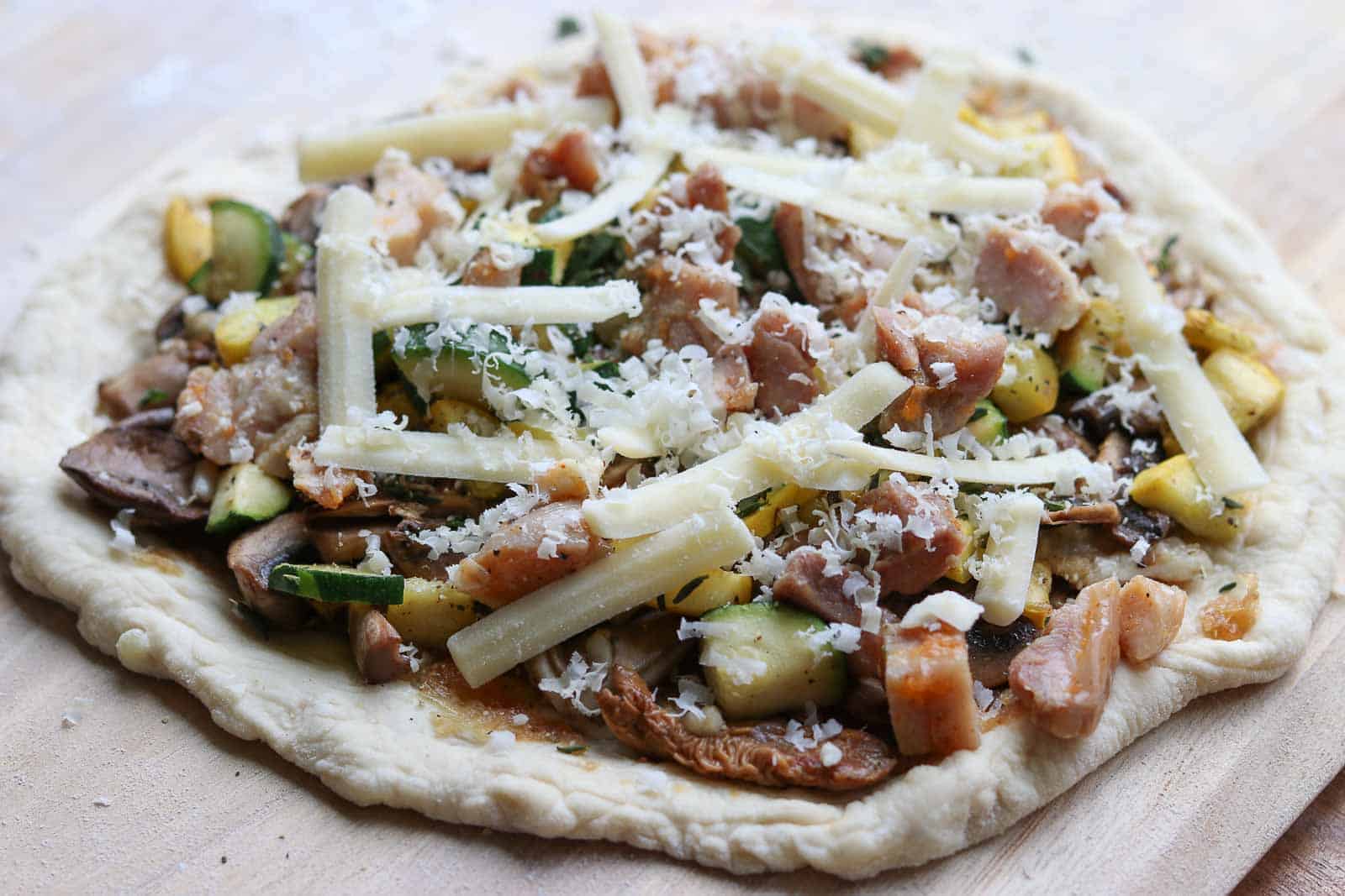 Pizza crust with toppings, not yet baked from Gourmet Done Skinny