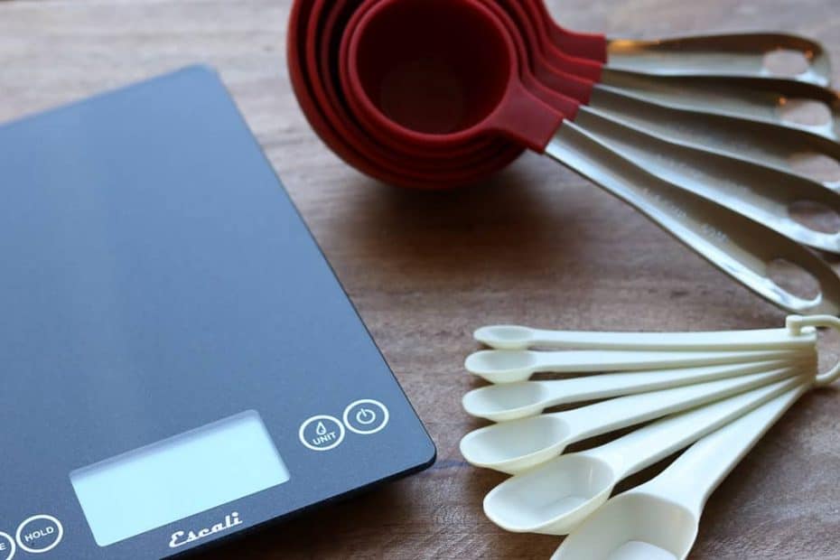 Digital scale, measuring cups and measuring spoons on a wooden board from Gourmet Done Skinny