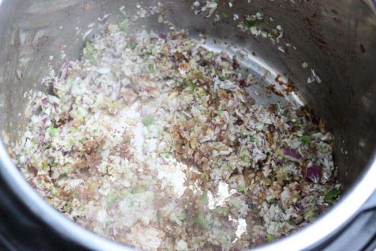 Finely chopped onions, garlic, jalapeno browning in an Instant Pot liner from Gourmet Done Skinny
