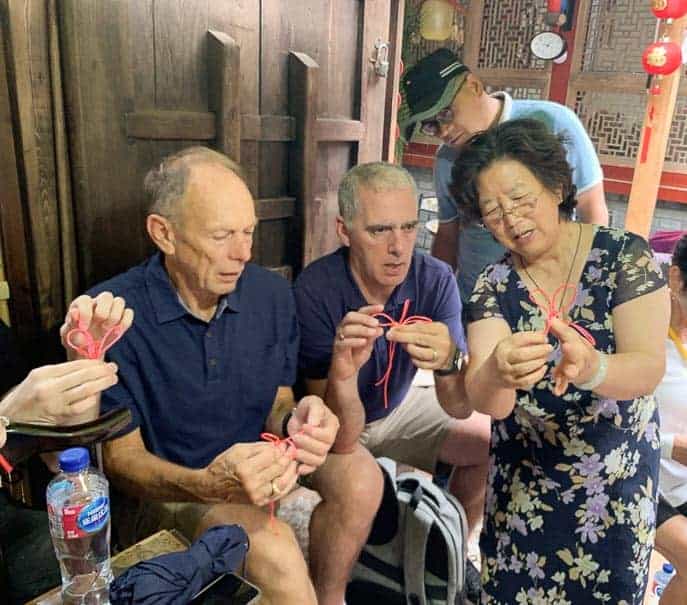 Tom and Pat learning to tie knots on the Hutong pedicab tour