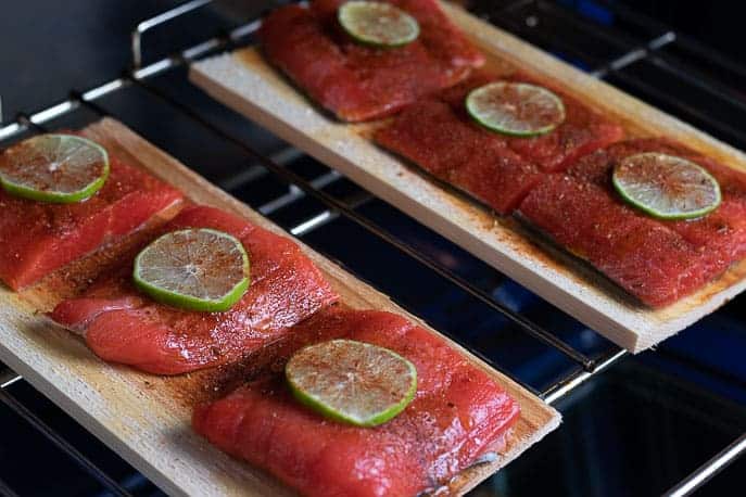Cedar planks with salmon, chipotle seasoning and lime in the oven