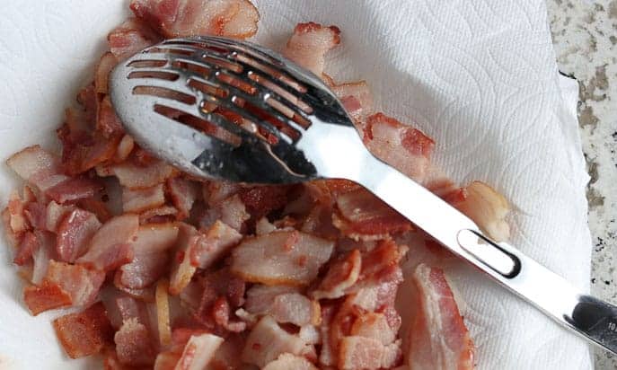 Cooked bacon on a paper towel with slotted spoon from Gourmet Done Skinny