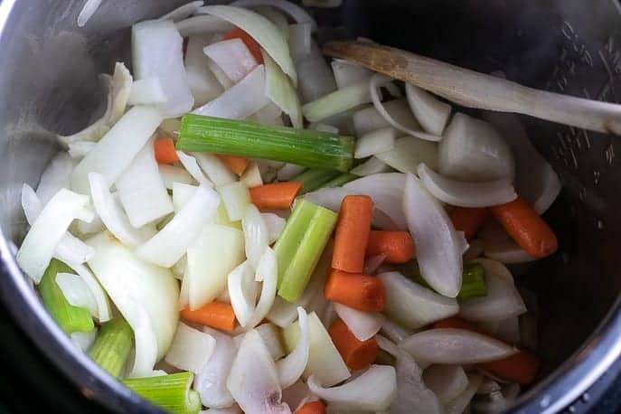Onions, celery and carrots in the Instant Pot sautéeing from Gourmet Done Skinny