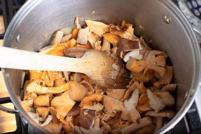 Mushrooms in a large pot with wooden spoon from Gourmet Done Skinny