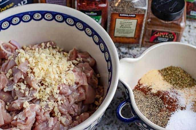 Homemade Spicy Chicken Sausage - chicken in bowl with garlic, spices in another bowl, on the counter from Gourmet Done Skinny