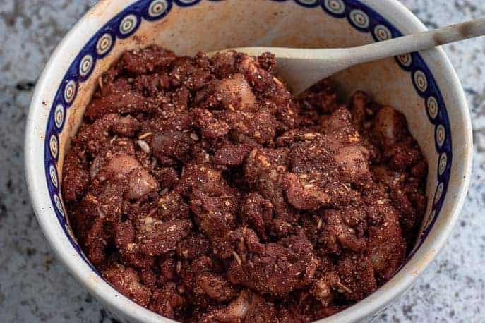 Homemade Spicy Chicken Sausage in a bowl on the counter with a wooden spoon from Gourmet Done Skinny