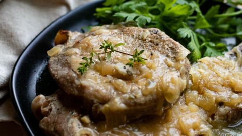 Healthy Instant Pot Pork Chops on a black plate with parsley from Gourmet Done Skinny
