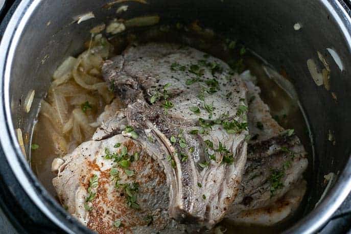 Browned pork chops, onions and remaining ingredients in Instant Pot from Gourmet Done Skinny
