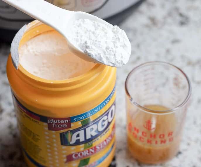 Cornstarch, tablespoon and small glass cup