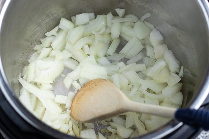 Chopped onions in the Instant Pot with spoon from Gourmet Done Skinny