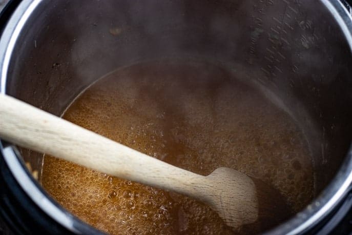 Gravy in Instant Pot with wooden spoon