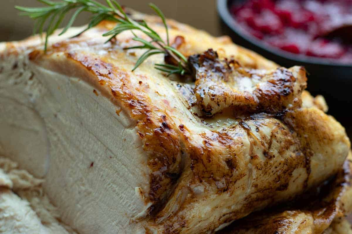 Browned turkey with cranberry sauce in background