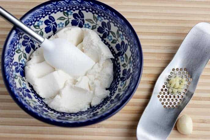 Blue Polish pottery bowl with ricotta, minced garlic on a cutting board