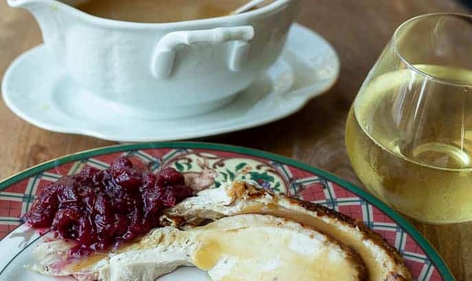 Plate with cranberry sauce, turkey, gravy and white wine