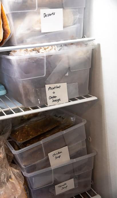 Picture of a freezer with homemade freezer meals in plastic boxes