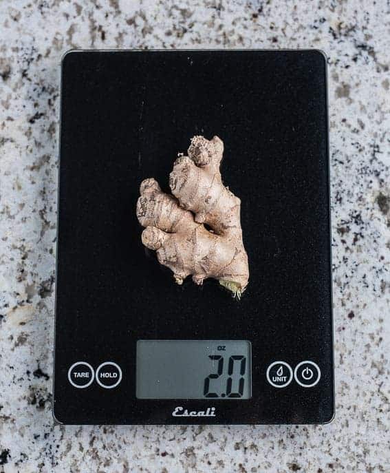 Large piece of ginger on a scale weighing 2 oz.