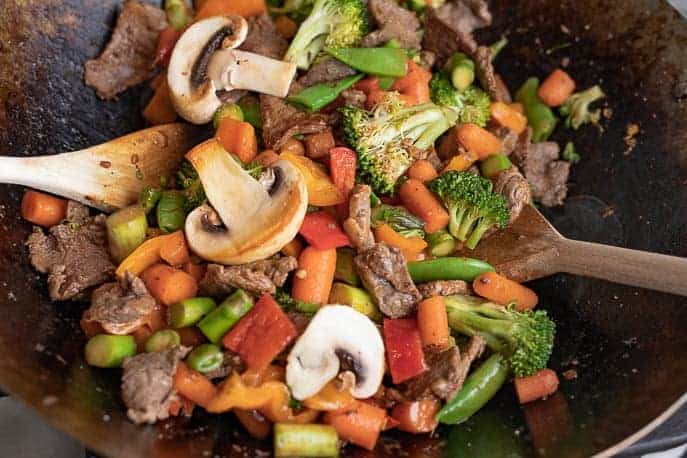 Clean Out Your Refrigerator Stir Fry in a wok with wooden spoons