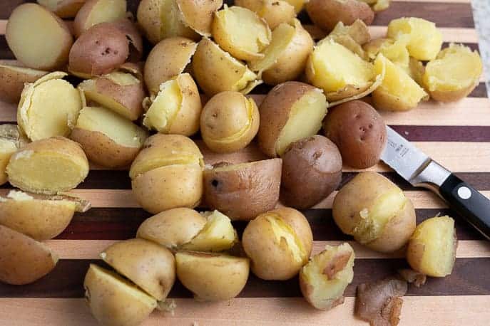 Cooked cut potatoes with knife on a cutting board