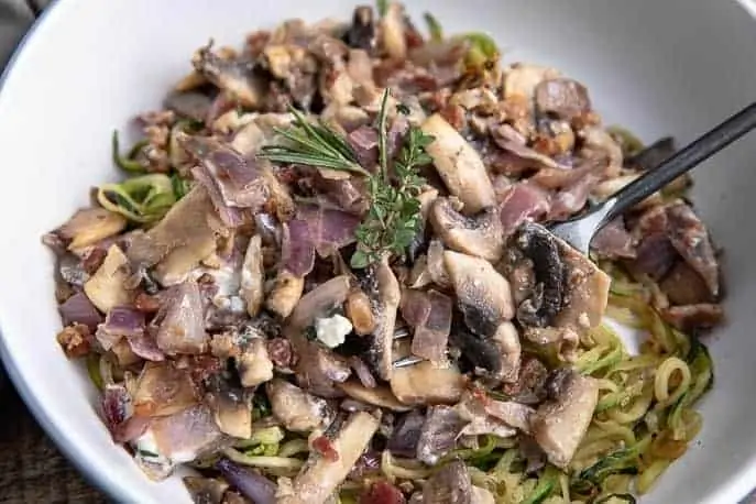 Creamy Blue Cheese Mushroom Pasta with Zoodles in a white bowl with black fork