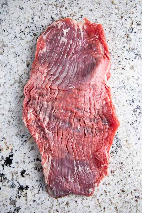 Raw flank steak on a granite counter