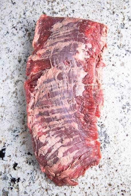 Raw skirt steak on a granite counter