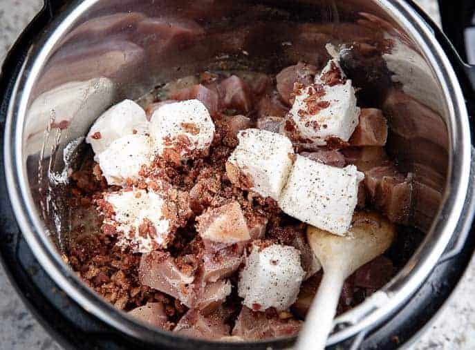Instant Pot with chicken, bacon and cream cheese and wooden spoon