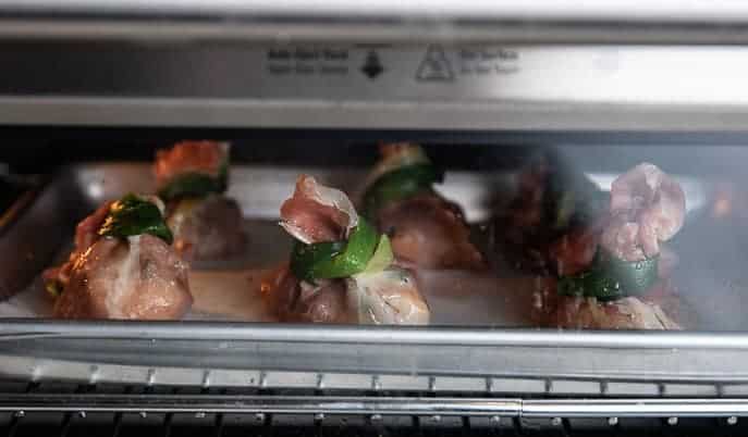 prosciutto bundles on a baking sheet in a toaster oven