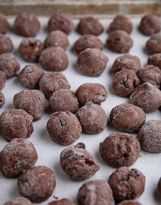 Spicy Chocolate Snap cookie balls on parchment paper on a pan ready to be flash frozen