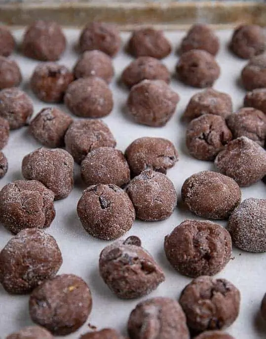 Spicy Chocolate Snap cookie balls on parchment paper on a pan ready to be flash frozen
