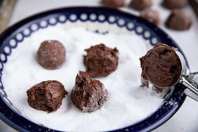 Spicy chocolate snaps cookie dough balls in white sugar with scoop