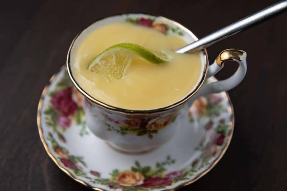 lime curd in a tea cup with piece of lime and spoon