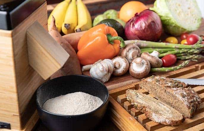 Fruits and vegetables, stone ground flour, fresh bread on a wooden board