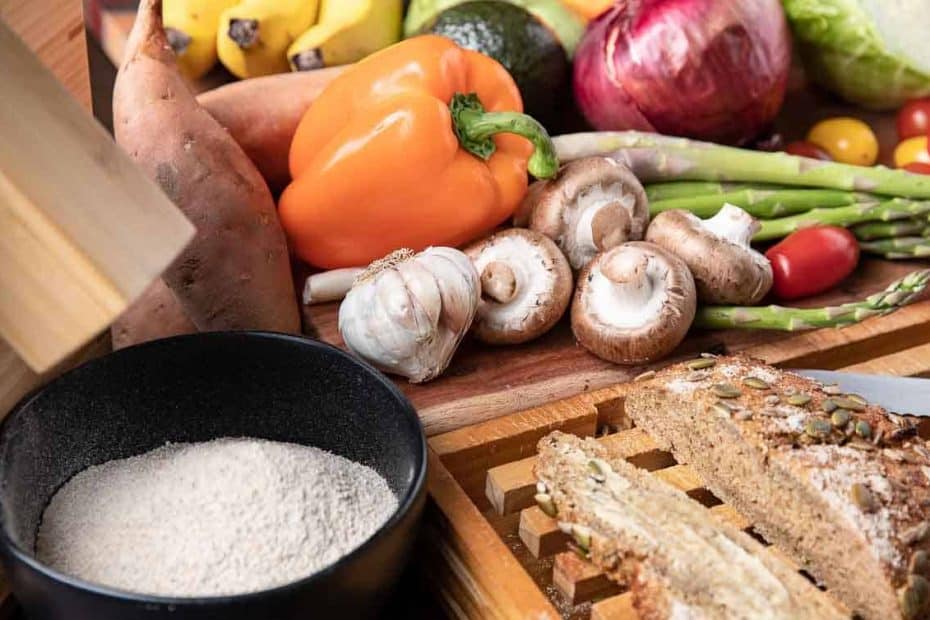 Fruits and vegetables, stone ground flour, fresh bread on a wooden board