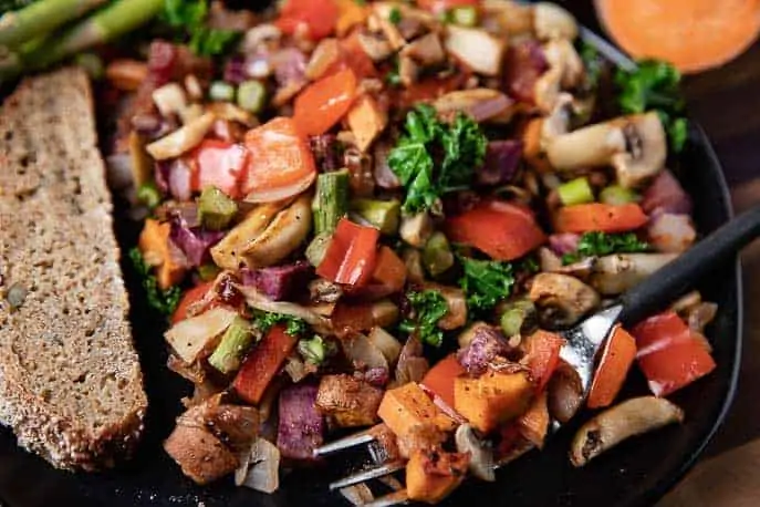 black plate with Sweet Potato Veggie Scramble and a piece of bread