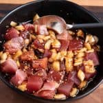 poke in a black bowl with spoon