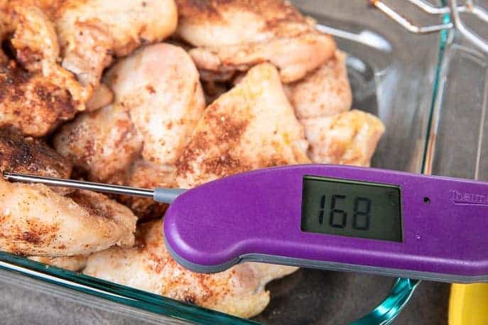 cooked chicken thighs with thermometer in a glass dish