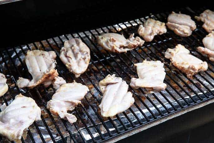 partially grilled chicken thighs on a grill