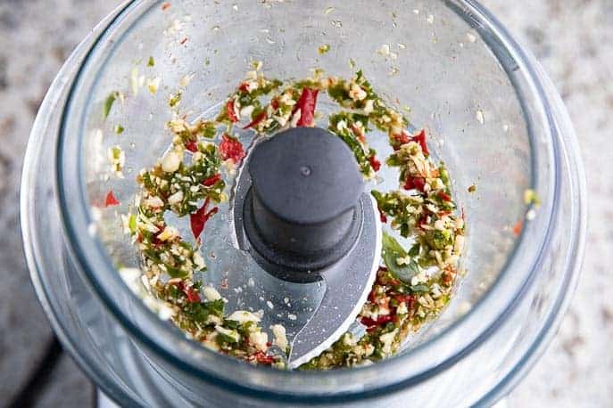 Jalapeno peppers and garlic in a food processor with blade
