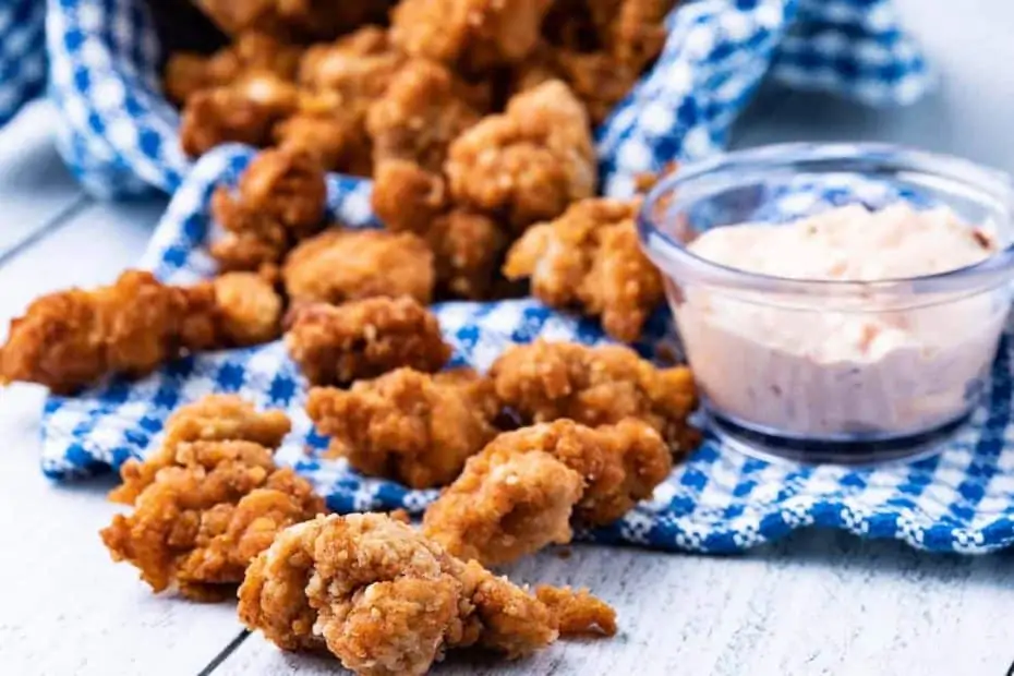 air fryer popcorn chicken on a board with sauce